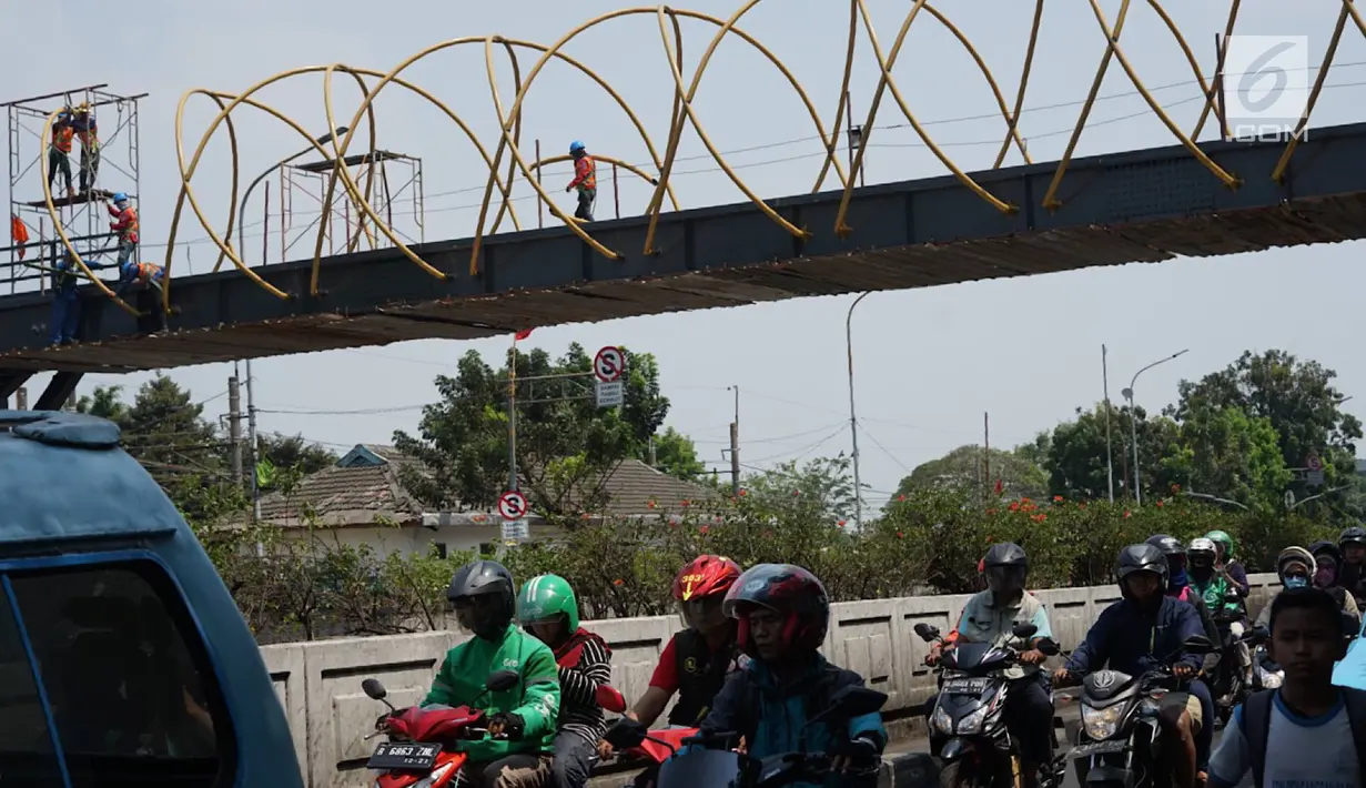 Kendaraan melintas di bawah proyek pembangunan Jembatan Penyebaran Orang (JPO) Pasar Minggu di Jakarta Selatan, Kamis (26/9/2019). JPO berdesain artistik senilai Rp 7 miliar tersebut ditargetkan rampung pengerjaannya pada Desember 2019 mendatang. (Liputan6.com/Immanuel Antonius)