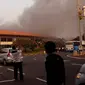 Sejumlah orang melihat kebakaran yang terjadi di Terminal 2E di Bandara Soekarno Hatta, Jakarta, Minggu (5/7/2015).  Kebakaran di Terminal 2E ini membuat panik ribuan penumpang yang sedang menunggu jadwal penerbangan. (Twitter@hanifahhas)