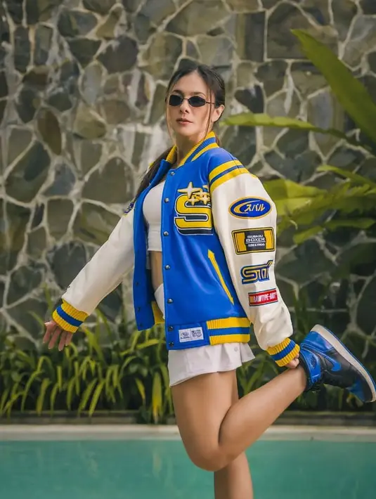 Wulan Guritno kerap tampil kekinian yang buatnya awet muda di usia 41 tahun. Kali ini, ia memadukan varsity jacket warna biru dengan crop top dan mini skirt serba putih. @wulangiritno