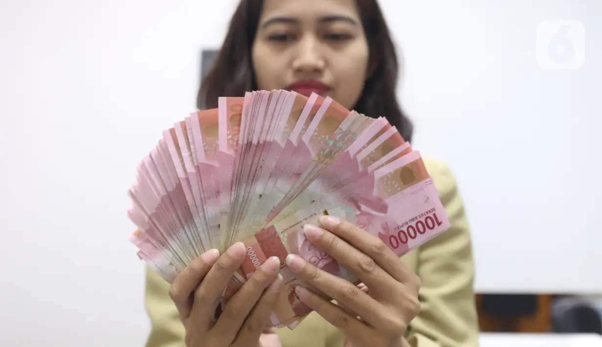 Pegawai menunjukkan mata uang rupiah di penukaran uang di Jakarta, Rabu (4/3/2020). Rupiah ditutup menguat 170 poin atau 1,19 persen menjadi Rp14.113 per dolar AS dibandingkan posisi hari sebelumnya Rp14.283 per dolar AS. (Liputan6.com/Angga Yuniar)