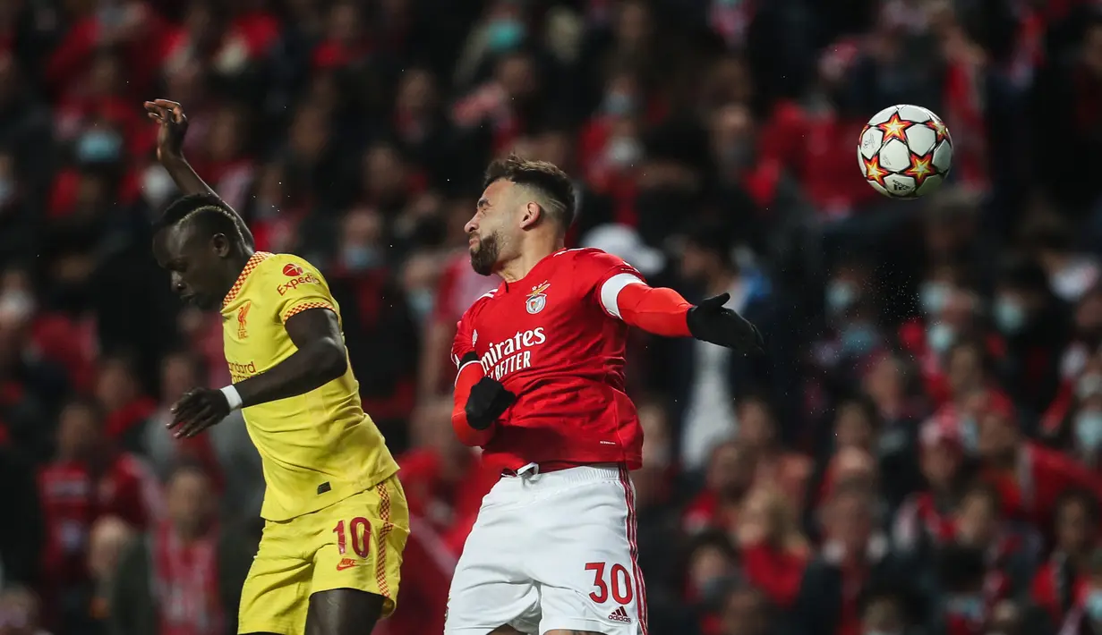 Penyerang Liverpool, Sadio Mane (kiri) berebut bola dengan bek Benfica, Nicolas Otamendi dalam pertandingan leg pertama perempat final Liga Champions di stadion Luz di Lisbon (6/4/2022). Liverpool menang atas Benfica 3-1. (AFP/Carlos Costa)