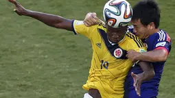 Pemain belakang Jepang, Yasuyuki Konno (kanan) berusaha menahan penyerang Kolombia, Adrian Ramos, saat berlaga di penyisihan Piala Dunia Grup C di Stadion Pantanal, Cuiaba, Brasil, (25/6/2014). (REUTERS/Suhaib Salem)