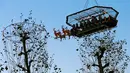 Tempat makan malam "Santa in the sky", yang diangkat dengan crane dan dihias menyerupai "Santa Sleigh" di Brussels, Belgia, 25 November 2016. Tempat makan malam ini didekorasi seperti kereta Santa Claus menjelang perayaan Natal. (REUTERS/Yves Herman)