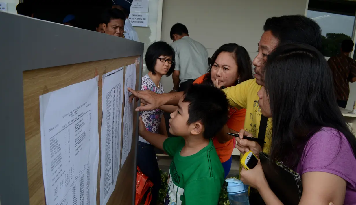 Sejumlah keluarga penumpang pesawat AirAsia QZ 8501 melihat daftar nama penumpang di Crisis Center Air Asia di Terminal 2 Bandara Juanda, Surabaya, Minggu (28/12/2014). (ANTARA FOTO/Suryanto)