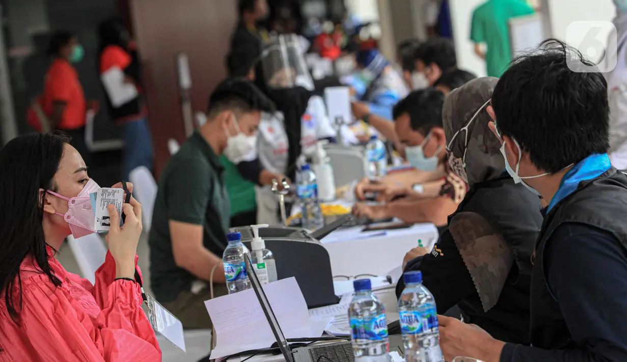 Petugas melakukan pendataan saat program vaksinasi COVID-19 kepada para atlet di Istora Senayan, Jakarta, Jumat (26/2/2021). Sebanyak 5.000 atlet diprioritaskan karena mereka dijadwalkan mengikuti beberapa kejuaraan single event maupun multievent dalam waktu dekat. (Liputan6.com/Faizal Fanani)