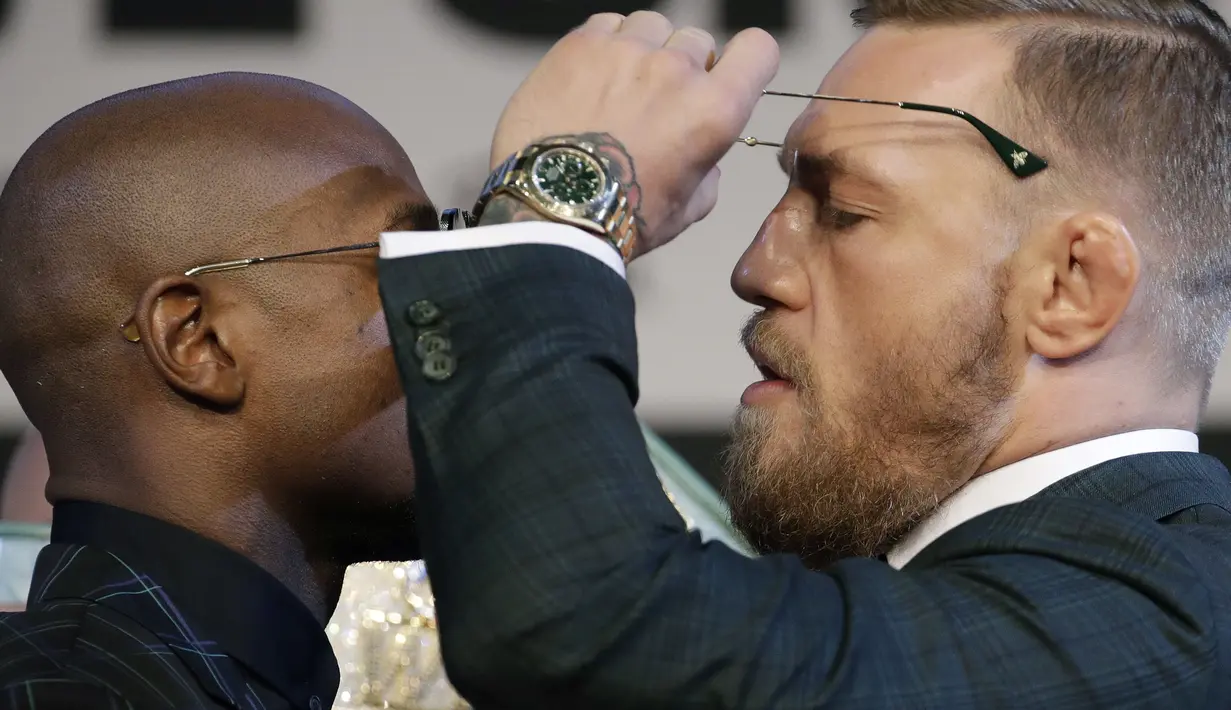 Tatapan Conor McGregor (kanan) saat melepas kaca mata kearah Floyd Mayweather Jr. saat konferensi pers di MGM Grand, Las Vegas, (23/8/2017). Mereka akan bertarung pada 26 Agustus 2017 atau Minggu pagi. (AP/John Locher)