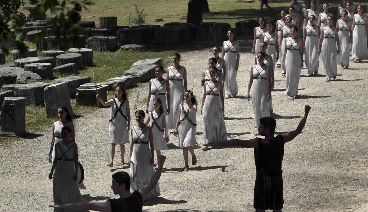 Iringan para aktris seusai upacara penyalaan api olimpiade di Candi Hera yang terletak di bekas kota tua Olympia, Yunani, Kamis (21/4/2016). (AFP/Aris Messinis)