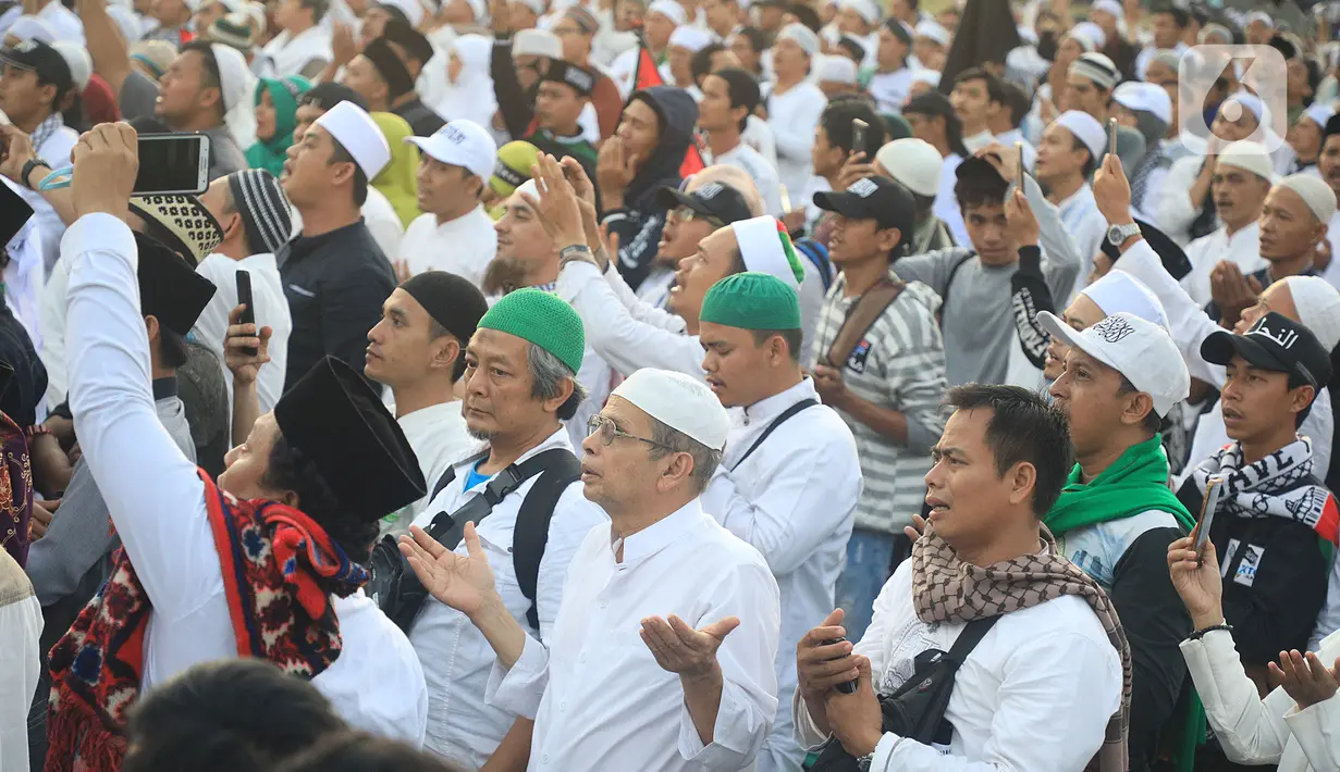 Massa berdoa saat mengikuti acara Munajat dan Maulid Akbar 2019 #ReuniMujahid212 di kawasan Monas, Jakarta, Senin (2/12/2019). Dalam acara tersebut, massa turut mendoakan agar Imam Besar FPI Rizieq Shihab segera dipulangkan. (Liputan6.com/Herman Zakharia)