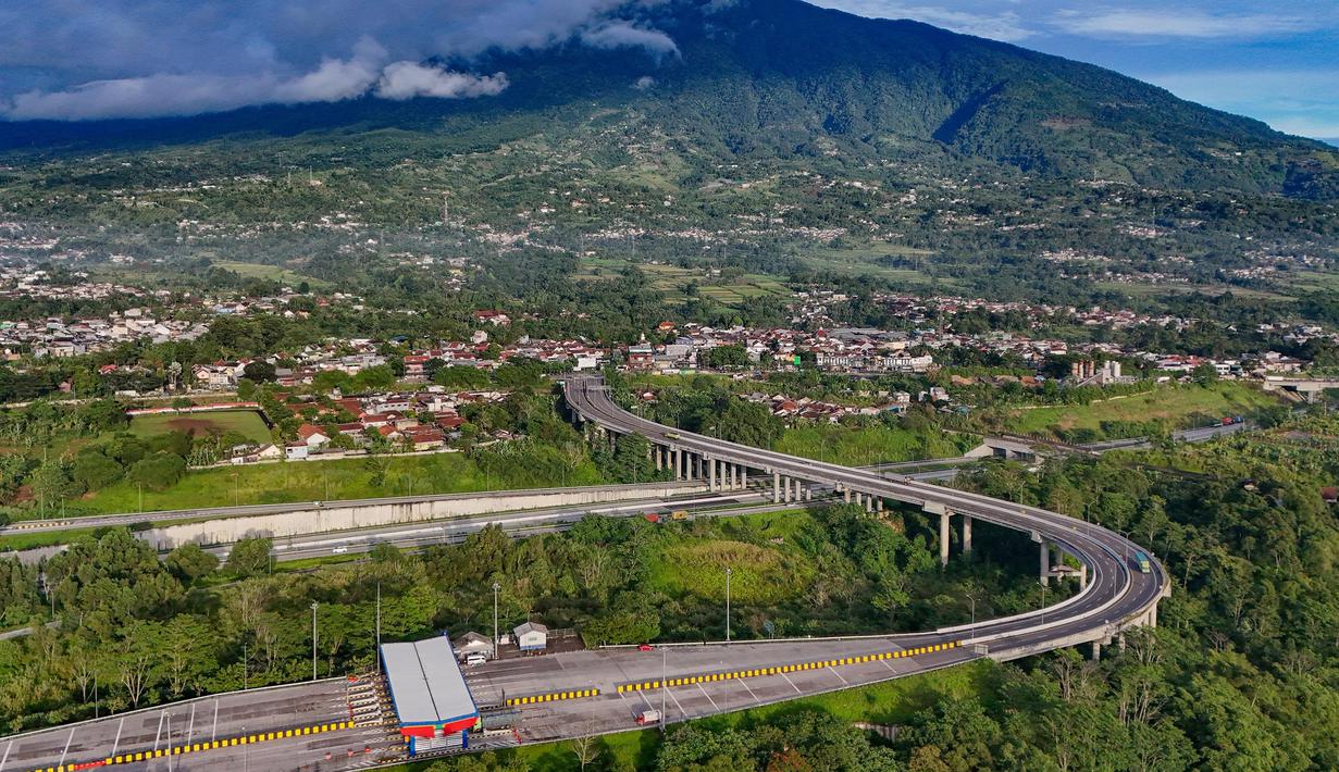 Foto udara memperlihatkan ruas Jalan Tol Bogor-Ciawi-Sukabumi (Bocimi) dengan latar belakang Gunung Salak di Cibadak, Kabupaten Sukabumi, Jawa Barat, Jumat (31/10/2025). Dengan latar keindahan alam seperti Gunung Salak dan panorama Sukabumi, kehadiran tol ini diharapkan mempercepat arus wisatawan serta distribusi barang dan jasa. (merdeka.com/Arie Basuki)