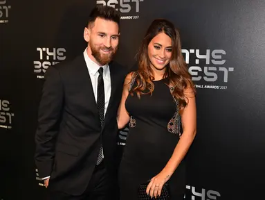 Bintang Argentina, Lionel Messi dan istrinya, Antonella Roccuzzo berpose setibanya di The Best FIFA Football Awards, London, Senin (23/10). Sejumlah penghargaan diberikan FIFA kepada para pelaku penting di dalam dan luar lapangan hijau. (Glyn KIRK/AFP)