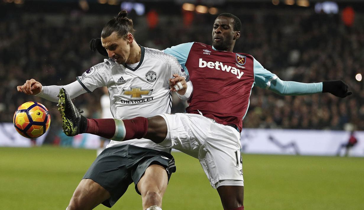 Striker Manchester United, Zlatan Ibrahimovic, berebut bola dengan gelandang West Ham, Pedro Obiang. Meski bermain tandang, MU lebih menguasai bola dengan prosentase penguasaan bola mencapai 64 persen. (AFP/Adrian Dennis)