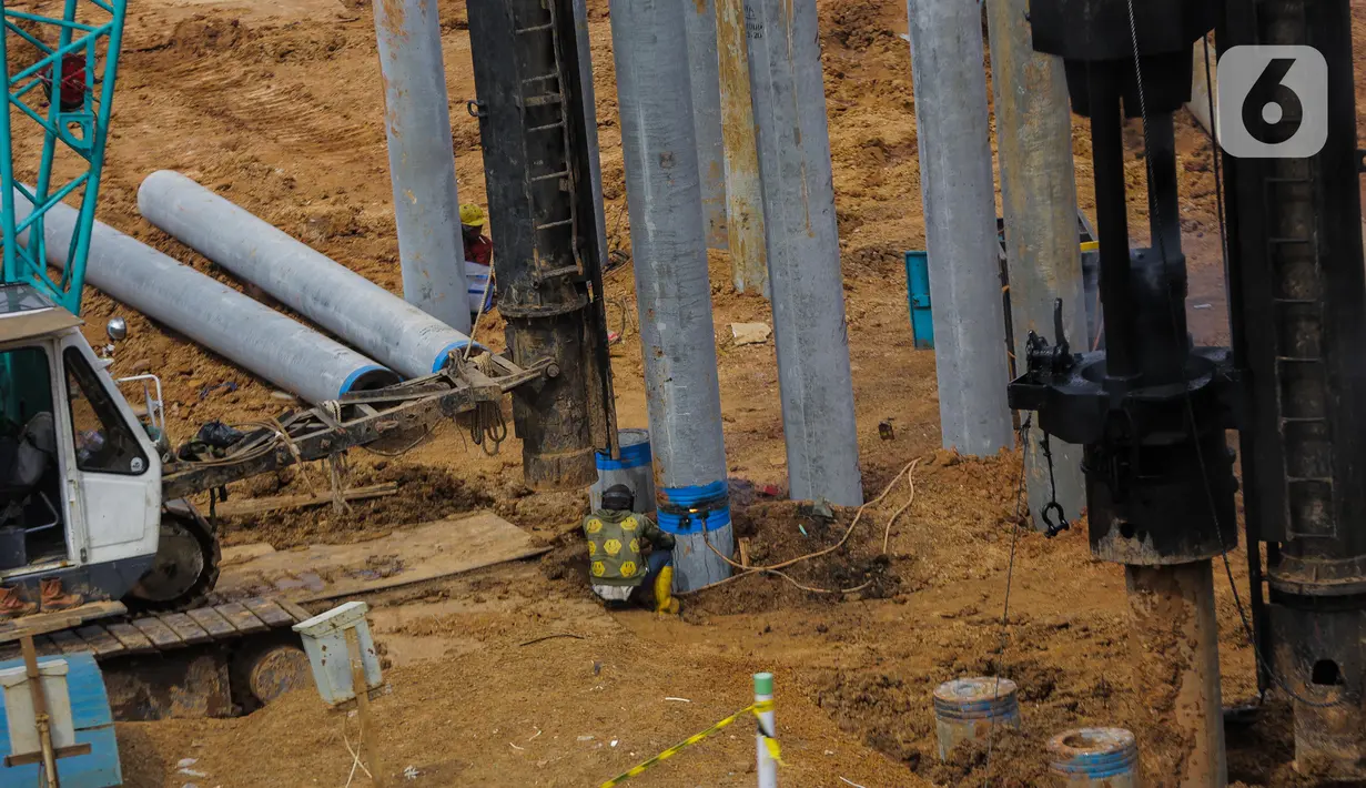 Pekerja mengatur pemasangan paku bumi dalam proyek pembangunan Pasar Senen Blok I dan II di kawasan Pasar Senen, Jakarta Pusat, Rabu (11/3/2020). Pasar Senen Blok I dan II yang menempati lahan 69.600 meter persegi tersebut dibangun kembali setelah kebakaran pada 2017.  (Liputan6.com/Faizal Fanani)