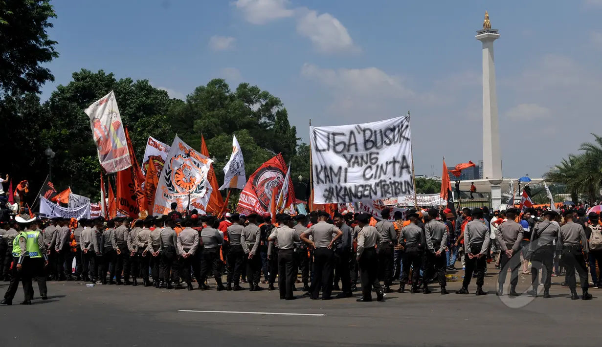 Aparat kepolisian berjaga mengamankan aksi puluhan ribu Jakmania (suporter tim Persija) di depan Istana Negara, Jakarta, Selasa (5/5/2015). Jakmania meminta Presiden Jokowi turun tangan menyelesaikan masalah sepak bola nasional. (Liputan6.com/Johan Tallo)