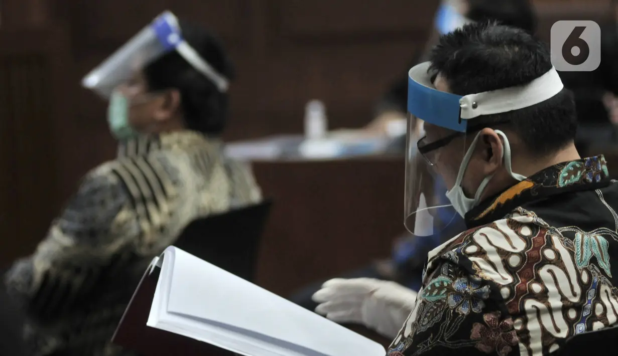 Para terdakwa mengenakan masker dan face shield saat menjalani sidang perdana kasus korupsi PT Asuransi Jiwasraya di Pengadilan Tipikor, Jakarta, Rabu (3/6/2020). Sidang yang menghadirkan enam terdakwa tersebut menerapkan protokol social distancing. (merdeka.com/Iqbal S. Nugroho)