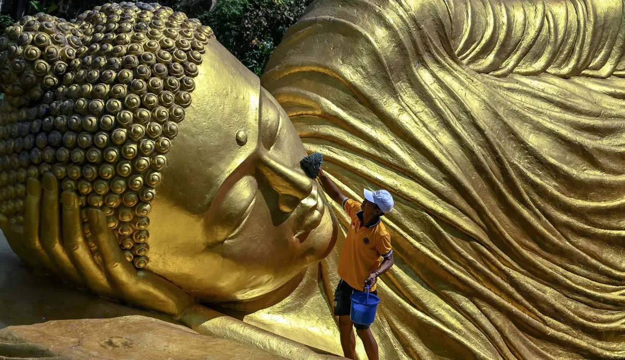 Ritual memandikan patung Buddha Maha Paranibbana atau yang biasa disebut patung Buddha tidur merupakan tradisi di Maha Vihara Mojopahit, Mojokerto. (JUNI KRISWANTO/AFP)