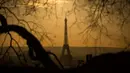Pemandangan Menara Eiffel yang diselimuti kabut polusi, Paris, Prancis (3/12). Kondisi berkabut ini terjadi karena dinginnya udara malam dan hangatnya suhu siang hari, sehingga polusi kendaraan terperangkap dan sulit hilang. (AFP/Lionel Bonaventure)