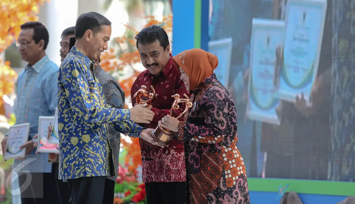 Presiden Jokowi memberikan piagam kepada Walikota Surabaya, Tri Rismaharini (kanan) saat acara puncak Peringatan Hari Anak Nasional di Istana Bogor, Jawa Barat, Selasa (11/8/2015). (Liputan6.com/Faizal Fanani)