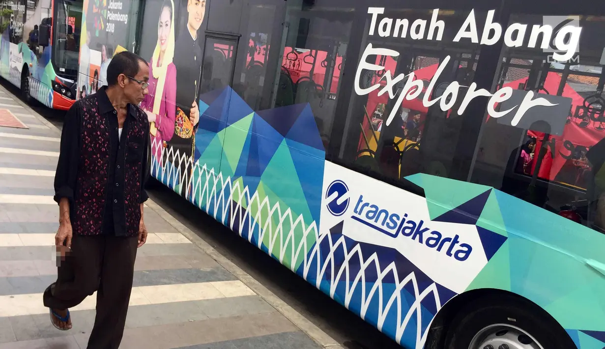 Warga melintas di samping bus transjakarta di Jalan Jati Baru Raya, Jakarta, Jumat (22/12). Terkait penataan PKL, Pemprov DKI Jakarta mulai menutup sepanjang jalan di depan Stasiun Tanah Abang pukul 08.00-18.00 WIB. (Liputan6.com/Immanuel Antonius)