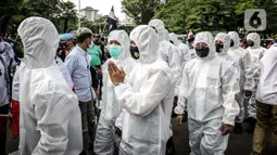 Petugas Satgas COVID-19 dari personel kepolisian menjaga protokol kesehatan peserta aksi solidaritas untuk Palestina di depan Kedutaan Besar Amerika Serikat, Jakarta, Selasa (18/5/2021). Massa mengutuk dan mengecam keras kekerasan yang dilakukan Israel atas Palestina. (Liputan6.com/Faizal Fanani)