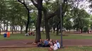 Pengunjung bercengkerama di sekitar Taman Monas, Jakarta, Rabu (17/1). Gubernur Anies Baswedan melalui Kepala Unit Pengelola Kawasan (UPK) Monas mencabut larangan menginjak rumput di kawasan tersebut. (Liputan6.com/Immanuel Antonius)