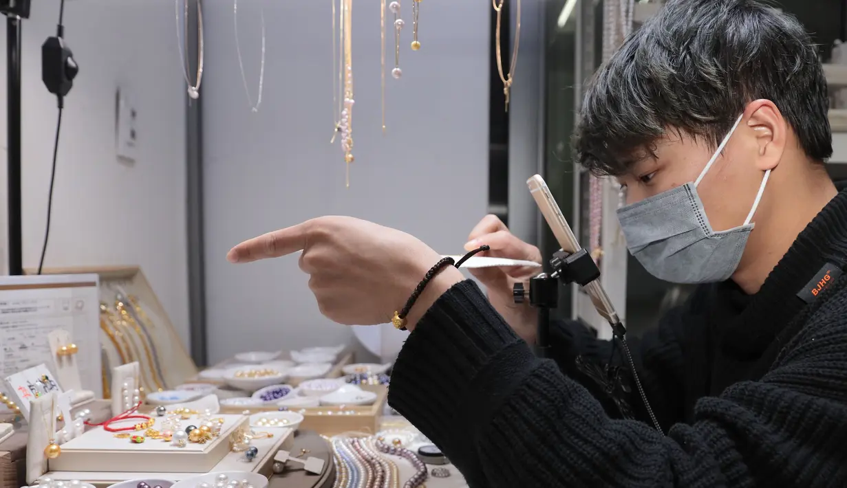 Seorang staf melakukan live streaming mempromosikan aksesori mutiara di Wilayah Xiahu, Zhuji, Provinsi Zhejiang, China (17/2/2020). Sejak munculnya wabah virus corona, pelaku usaha di Xiahu, salah satu basis produksi utama mutiara mempromosikan produk mereka lewat live streaming. (Xinhua/Guo Bin)