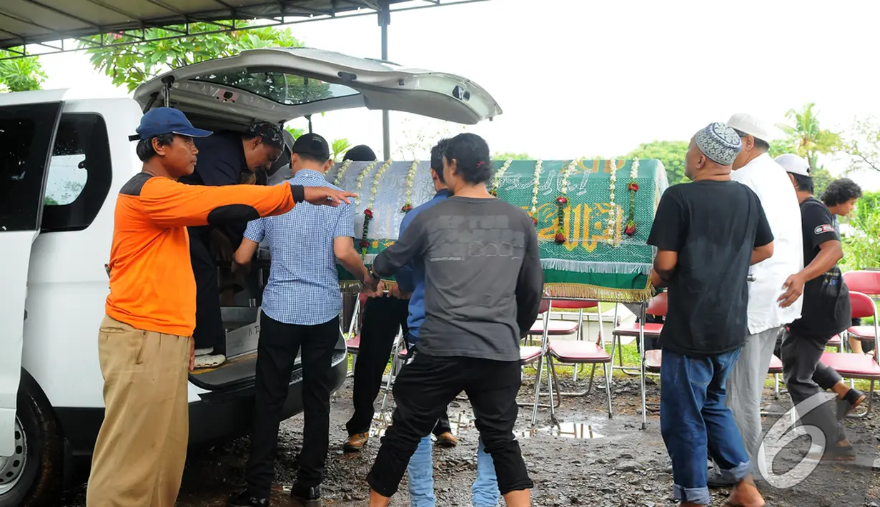 Jenazah ibunda Melly Goeslaw dikeluarkan dalam ambulance saat akan dimakamkan, TPU Tanah Kusir, Bintaro, Senin (12/1/2015). (Liputan6.com/Faisal R Syam)