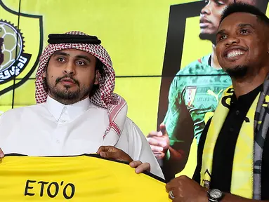 Penyerang asal Kamerun Samuel Eto'o berpose dengan jersey klub barunya  Qatar Sports Club selama presentasi dirinya di Doha, (14/8). Eks Striker Barcelona ini menandatangani kontrak selama satu tahun di klub tersebut. (AFP Photo/Karim Jaafar)