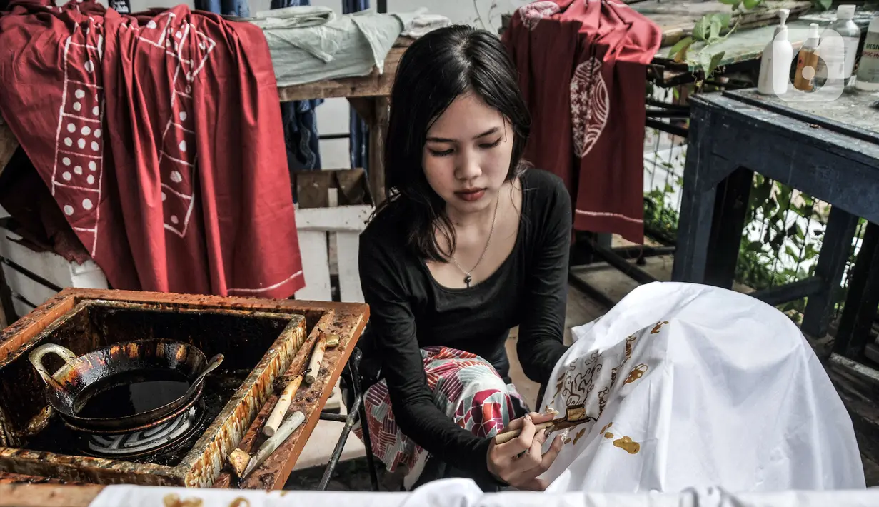 Pengunjung belajar membatik di Rumah Batik Palbatu, Jakarta, Minggu (2/10/2022). Dalam rangka memeriahkan Hari Batik Nasional, Rumah Batik Palbatu menggelar pelatihan membatik kepada masyarakat umum sebagai upaya meningkatkan minat terutama bagi generasi milenial dalam melestarikan seni kriya tersebut. (merdeka.com/Iqbal S. Nugroho)