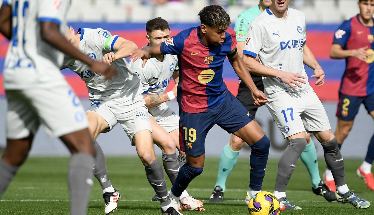 Pemain Barcelona, Lamine Yamal berusaha melewati penjagaan dari sejumlah pemain Deportivo Alaves dalam laga lanjutan Liga Spanyol 2024/2025 di Estadi Olimpic Lluis Companys, Barcelona, Spanyol, Minggu (02/02/2025) waktu setempat. (AFP/Josep Lago)