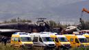 Tim medis bersama petugas kebakaran mencari korban di reruntuhan pesawat tentara Aljazair yang jatuh di dekat pangkalan udara Boufarik, Aljazair (11/4). Sebagian besar korban adalah personel militer dan keluarga mereka. (AP Photo/Anis Belghoul)