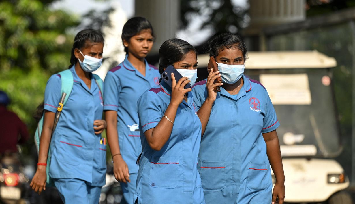Petugas kesehatan mengenakan masker saat berjalan keluar dari rumah sakit pemerintah, sejak peningkatan kasus Covid-19, di Chennai pada 1 April 2023.  (AFP/R.Satish Babu)