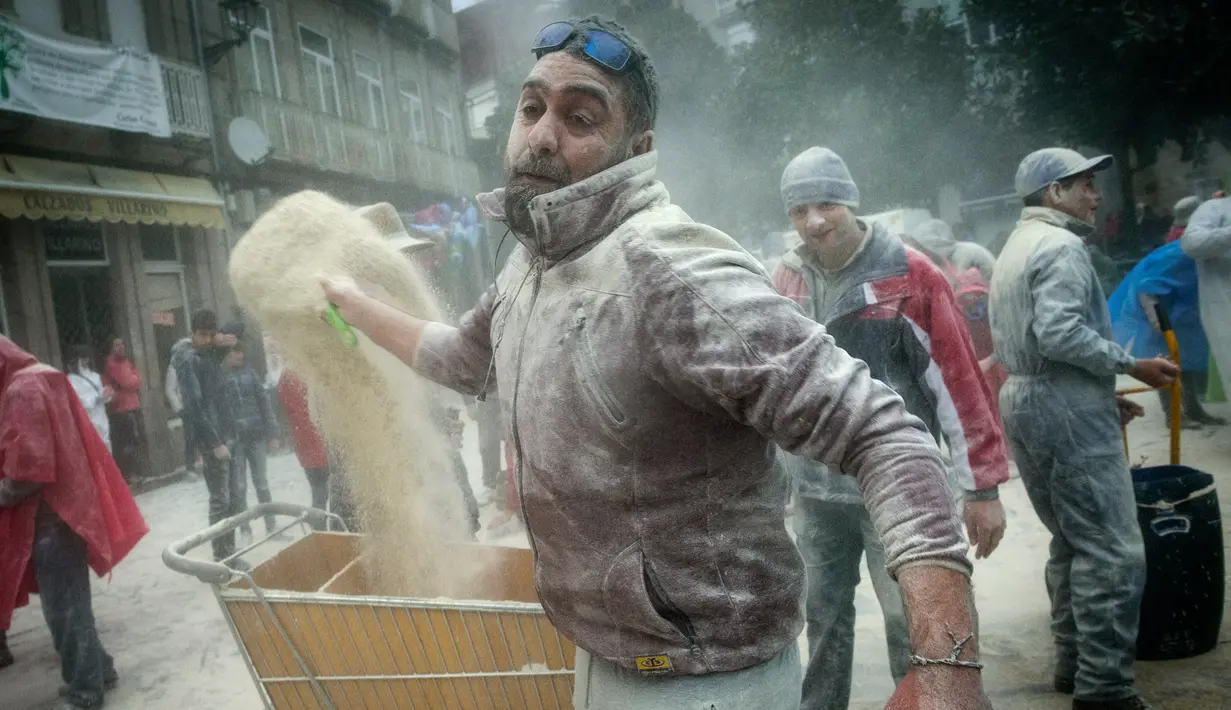 Seorang pria bersiap melempar tepung ke peserta lainnya saat mengikuti festival "Domingo Fareleiro" di desa Xinzo de Limia, Spanyol (21/1). Festival ini dikenal juga dengan nama Floury Sunday in Galician. (AFP/Miguel Riopa)