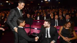 Bintang Barcelona, Lionel Messi, menyapa anak Cristiano Ronaldo saat acara penghargaan pemain terbaik FIFA 2017 di London, Senin (23/10/2017). Cristiano Ronaldo berhasil meraih pemain terbaik FIFA 2017. (AFP/Ben Stansall)