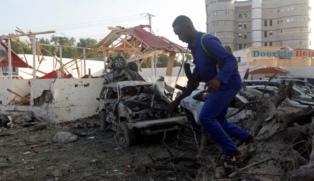 Tentara berjaga di sekitar bangunan yang hancur menyusul serangan bom mobil kembar di Ibu Kota Mogadishu, Somalia, Sabtu (24/2). Ledakan kedua terjadi di dekat Istana Presiden Somalia. (AP Photo/Farah Abdi Warsameh)
