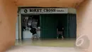 Intensitas curah hujan yang tinggi sejak Minggu (8/2) membuat Sungai Pesanggrahan meluap. Tampak pedagang menutup tokonya karena banjir yang melanda Pasar Cipulir, Jakarta, Selasa (10/2/2015).(Liputan6.com/Andrian M Tunay)