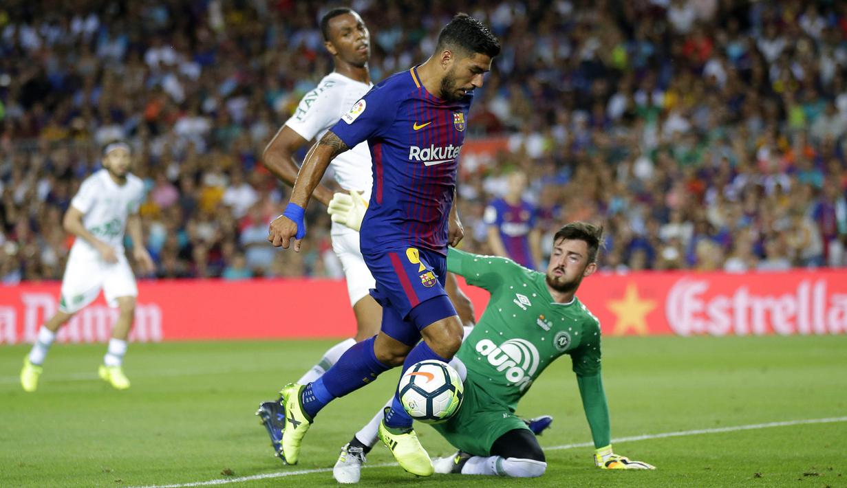 Striker Barcelona, Luis Suarez, berusaha melewati kiper Chapecoense, Elias, pada laga trofi Joan Gamper di Stadion Camp Nou, Barcelona, Senin (7/8/2017). Barcelona menang 5-0 atas Chapecoense. (AP/Manu Fernandez)