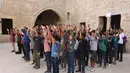 Anak-anak Palestina berdiri di halaman sekolah bersejarah "Al-Kamaliya al-Othmanya" saat mereka berolahraga sebelum masuk sekolah di Kota Tua Gaza yang menjadi bagian dari inisiatif sukarelawan yang diorganisir oleh para guru pengungsi, di Kota Gaza pada 2 November 2025. Banyak di antaranya kini dialihfungsikan menjadi tempat penampungan darurat yang menampung puluhan ribu pengungsi. (Omar AL-QATTAA/AFP)