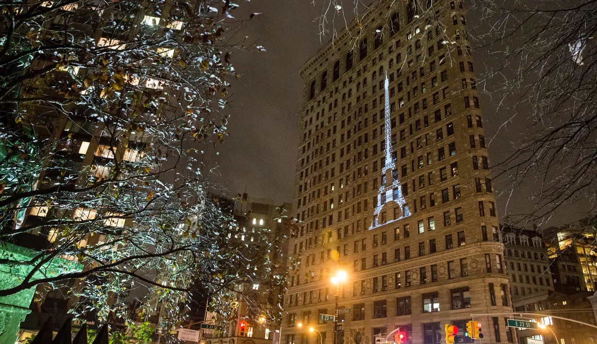 Proyeksi Menara Eiffel ditampilkan di sisi bangunan Flatiron New York City, Rabu (18/11). Gambar yang menampilkan tulisan 'She is tossed by waves but does not sink' itu bentuk solidaritas terkait serangan teror Paris. (Andrew Burton/Getty Images/AFP)