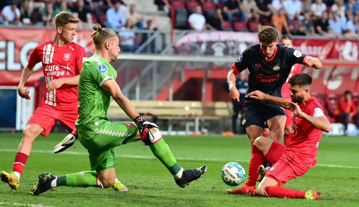 Pemain Twente, Mees Hilgers (kanan) menghalau bola tendangan pemain PSV, Guus Til (kedua kanan) pada laga lanjutan Liga Belanda 2022/2023 yang berlangsung di De Grolsch Veste Stadium, Enschede, Belanda, 3 September 2022. (AFP/ANP/Olaf Kraak)