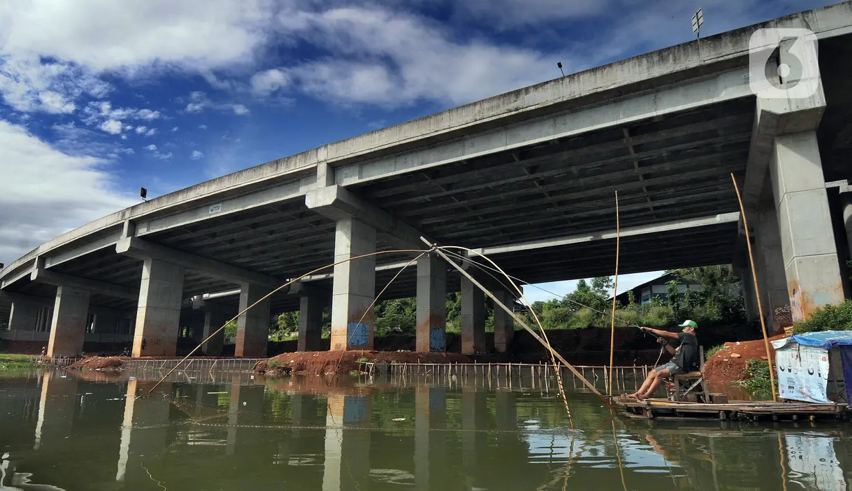 Warga menangkap ikan dengan jaring apung di bawah jalan Tol Serpong-Cinere, Setu Sasak Tinggi, Pamulang, Tangerang Selatan, Banten (6/4/2021). Setu Sasak Tinggi dimanfaatkan warga menangkap ikan mujair. (merdeka.com/Arie Basuki)