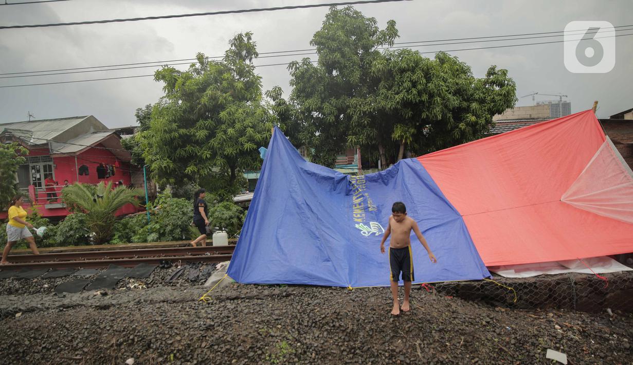 Tenda pengungsi banjir yang didirikan di jalur rel kereta commuterline Tangerang-Duri di Kembangan Baru, Jakarta, Jumat (3/1/2020). Jalur rel yang nonaktif sementara karena banjir dimanfaatkan warga untuk mendirikan tenda darurat karena rumah mereka masih terendam. (Liputan6.com/Faizal Fanani)