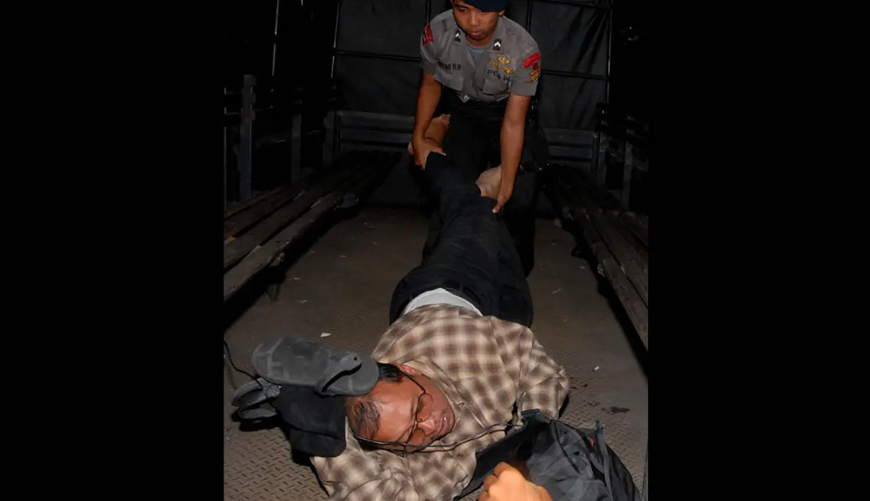 Salah seorang massa terlihat digotong pihak keamanan lantaran menolak berjalan, Jakarta, Senin (4/8/14). (Liputan6.com/Miftahul Hayat)