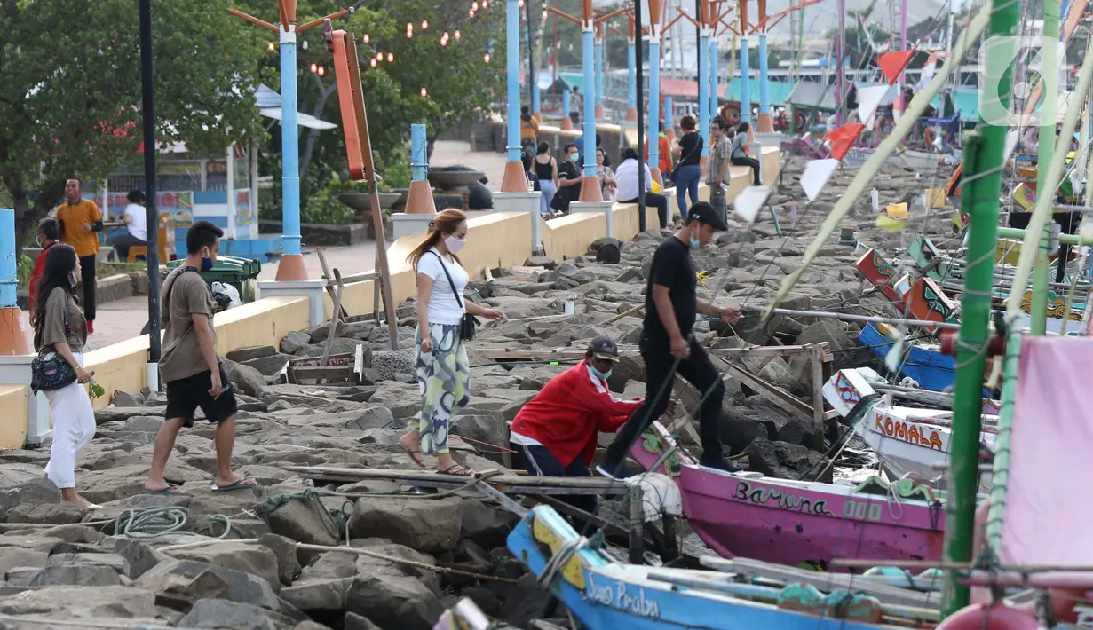 Pengunjung menikmati suasana Pantai Indah Taman Impian Jaya Ancol dengan menumpang perahu wisata, Jakarta, Kamis (29/10/2020). Libur panjang di masa pemberlakuan PSBB transisi Jakarta dimanfaatkan warga untuk mengunjungi lokasi-lokasi wiisata. (Liputan6.com/Helmi Fithriansyah)