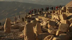 Gambar pada 23 September 2019 memperlihatkan wisatawan mengunjungi puncak Gunung Nemrut, Provinsi Adiyaman di Turki bagian tenggara. Pada puncak gunung yang berada di ketinggian 2.206 mdpl, terdapat puing reruntuhan Kerajaan Commagene. (AP/Emrah Gurel)