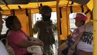 Seorang tentara mengintip ke dalam transportasi umum pada pemeriksaan keamanan yang ditempatkan oleh tentara di Duran, di seberang jembatan dari Guayaquil, Ekuador, Senin, 14 Agustus 2023. (AP Photo/Martin Mejia)