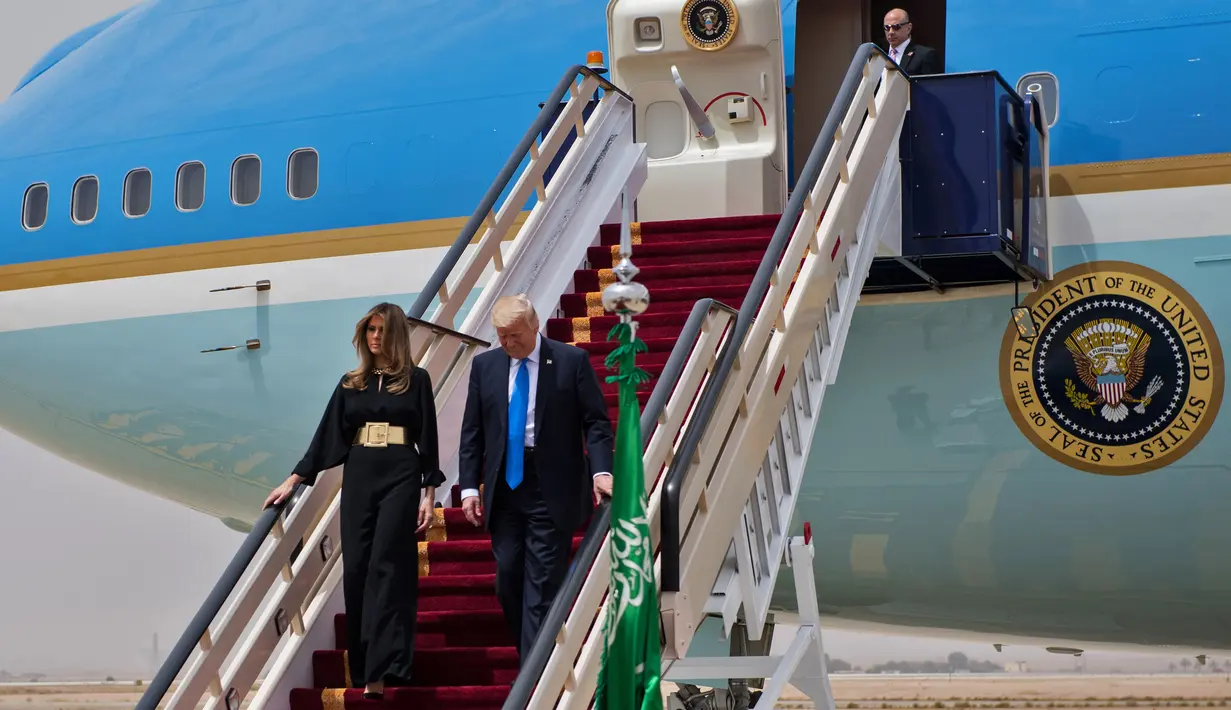 Presiden AS Donald Trump didampingi Melania Trump turun dari pesawat Air Force One saat tiba di Bandara Internasional Raja Khalid di Riyadh (20/5). (AFP Photo/Mandel Ngan)