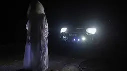 Urabil Alias, 38, mengenakan kostum hantu berdiri di depan mobil sekitar perumahan selama aturan pembatasan gerakan atau Movement Control Order di Terengganu, Malaysia, 16 April 2020. Aksi pria itu untuk menakuti warga agar tidak keluar rumah selama lockdown akibat virus corona. (Mohd RASFAN/AFP)