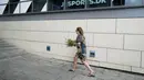 Seorang wanita membawa seikat bunga untuk meninggalkannya pada pintu masuk pusat perbelanjaan Field di Kopenhagen, Denmark, 4 Juli 2022. Polisi mengesampingkan bahwa serangan hari Minggu itu terkait dengan terorisme. (AP Photo/Sergei Grits)