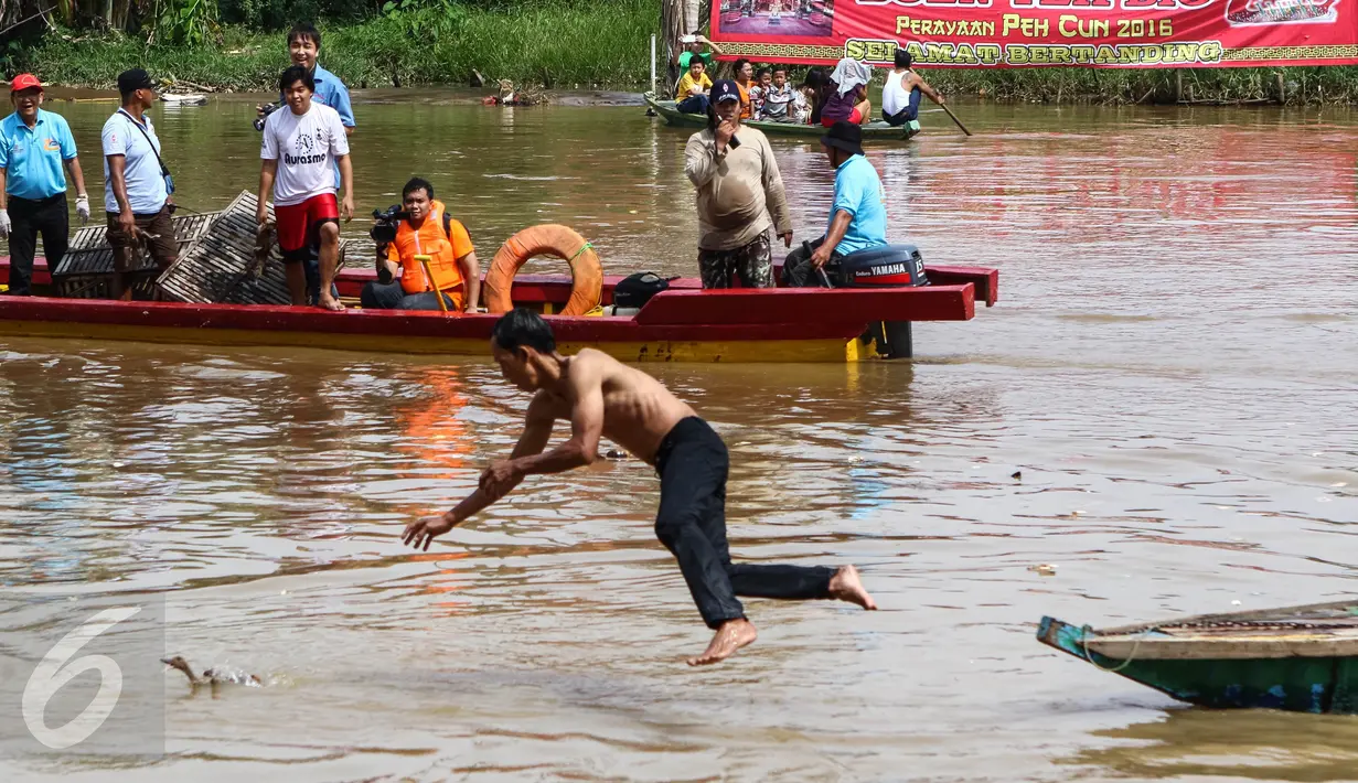 Warga melompat dari kapal untuk menangkap bebek yang dilempar ke kali Cisadane pada perayaan Peh Cun di Pasar Lama, Kota Tangerang, Kamis (9/6). Sulitnya menangkap bebek di air menjadi tontonan yang menarik bagi warga. (Liputan6.com/Fery Pradolo)