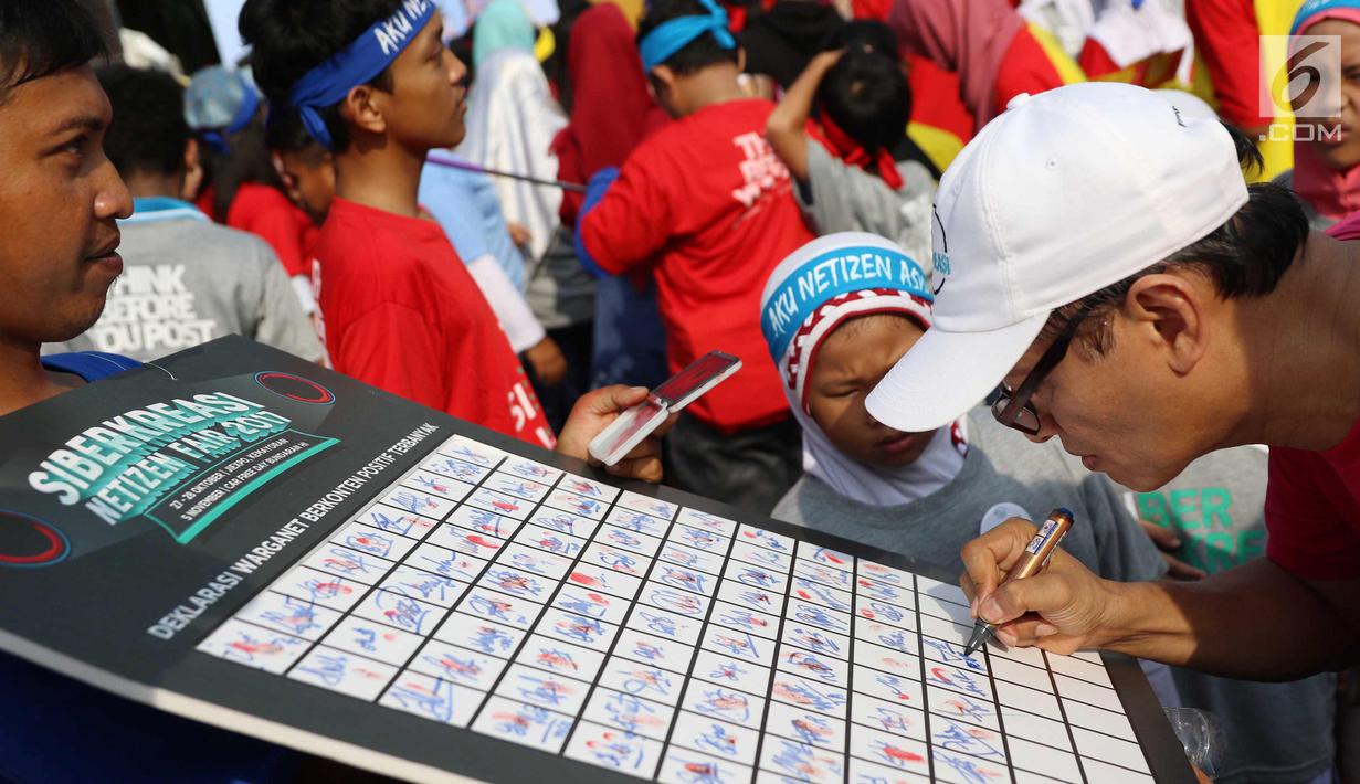 Seorang warga menandatangani dukungan deklarasi siber kreasi melawan hoax saat CFD di Jakarta, Minggu (5/11). Siber kreasi dibentuk dari berbagai komunitas dan elemen masyarakat. (Liputan6.com/Angga Yuniar)